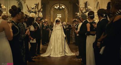 a woman in a wedding dress standing in front of a group of people