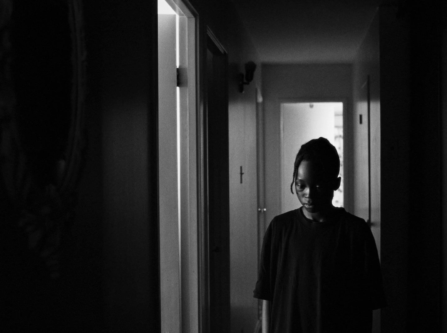 a person standing in a hallway in a dark room