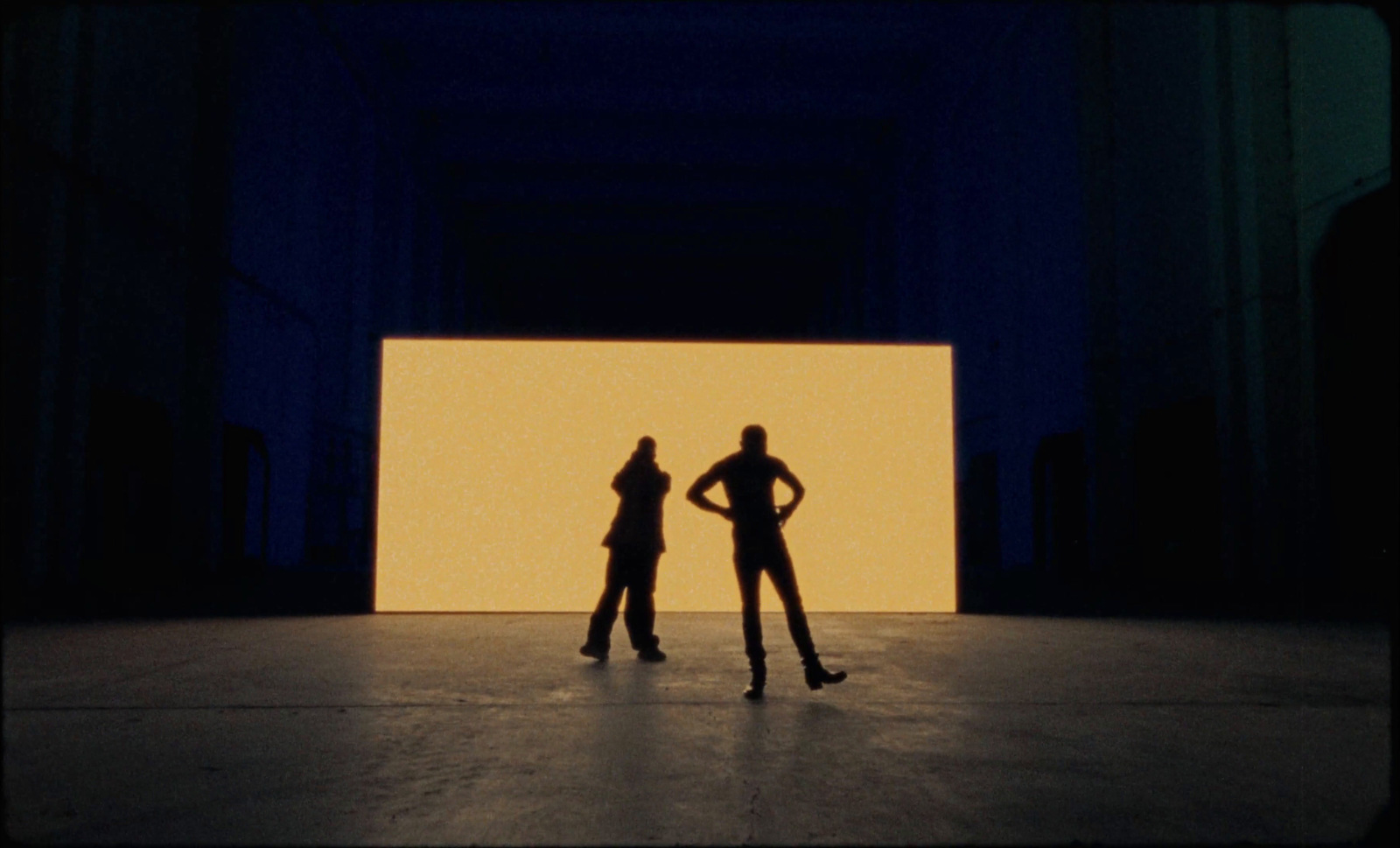 a couple of people standing in front of a wall