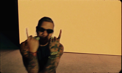 a man with tattoos making a peace sign