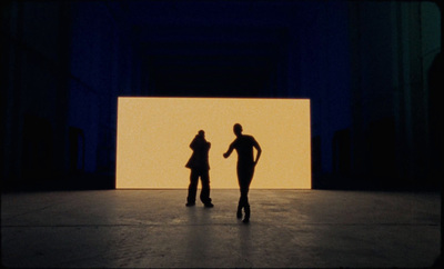 a couple of people standing in front of a wall