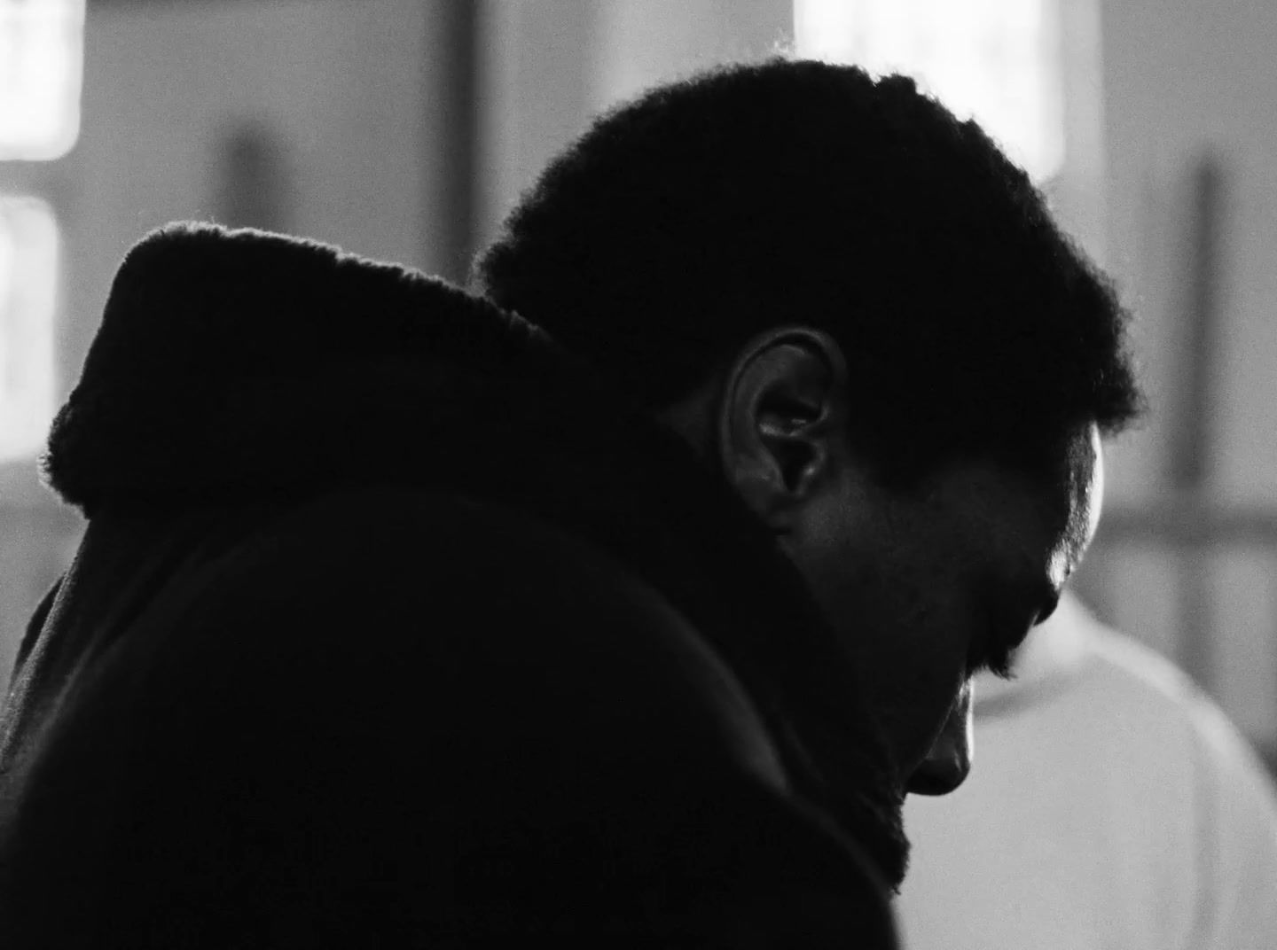 a black and white photo of a man looking down