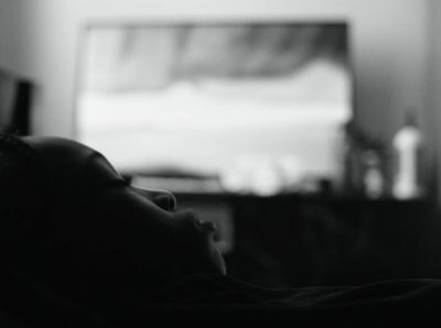 a black and white photo of a person laying in bed