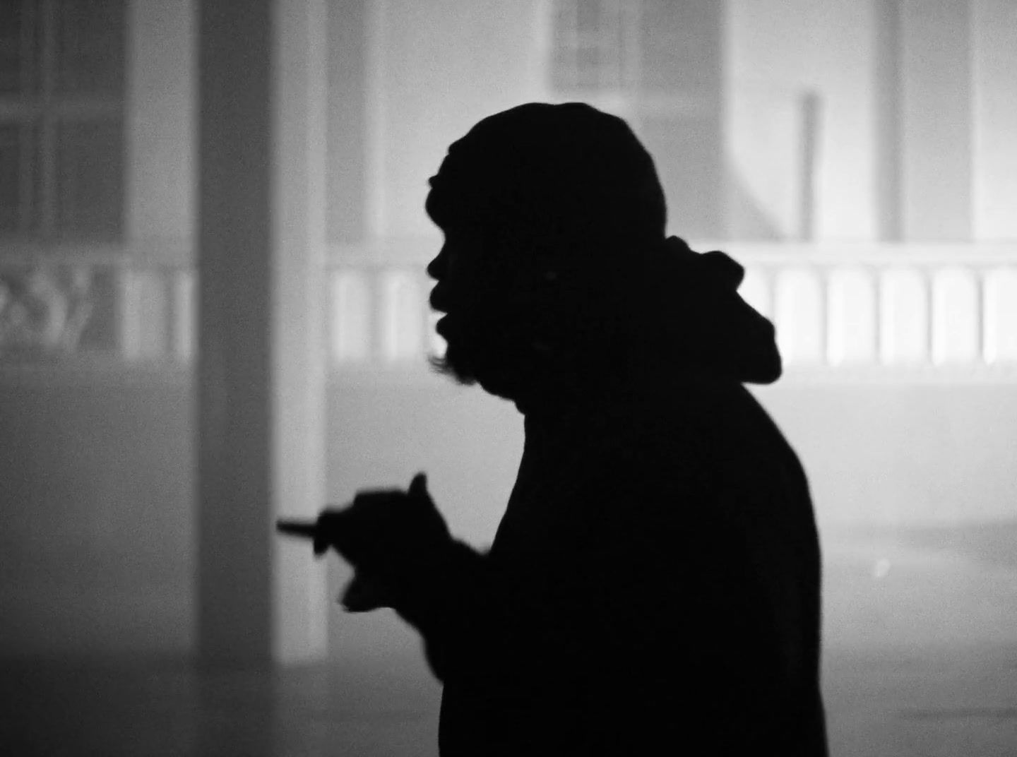 a silhouette of a person holding a cigarette