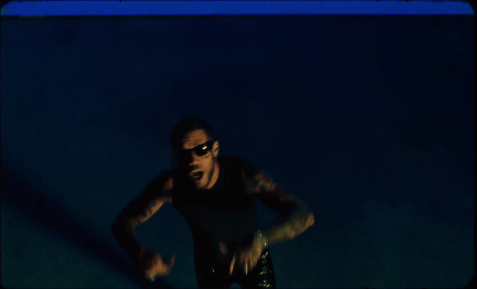 a man in sunglasses is running in the dark