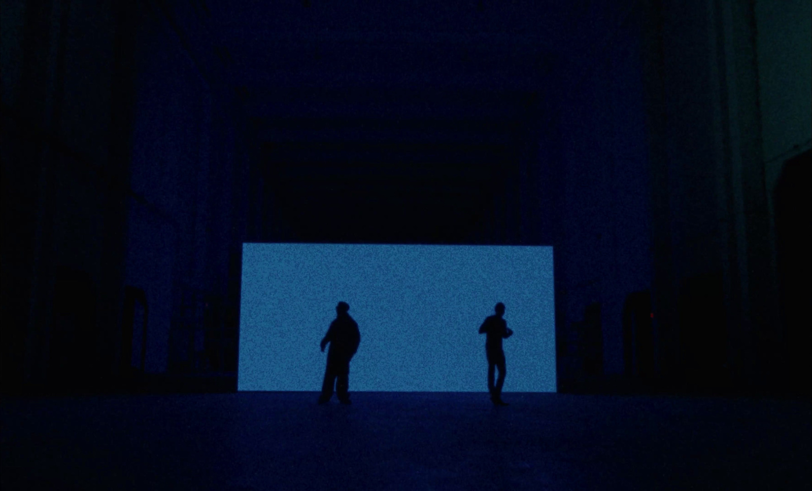 a couple of people standing in a dark room