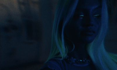 a woman with long blonde hair in a dark room