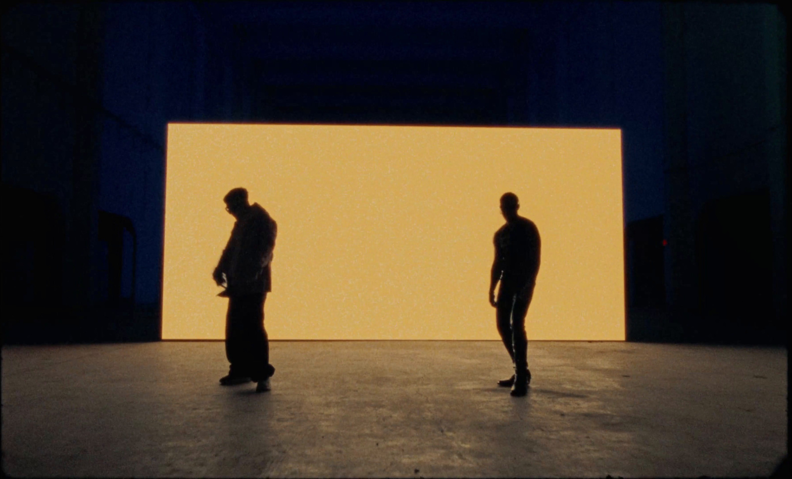 a couple of men standing in front of a wall