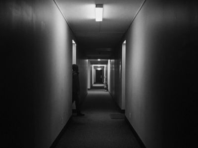 a dark hallway with a person walking down it