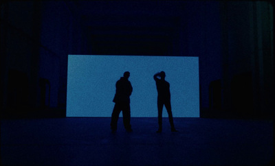 two people are standing in a dark room