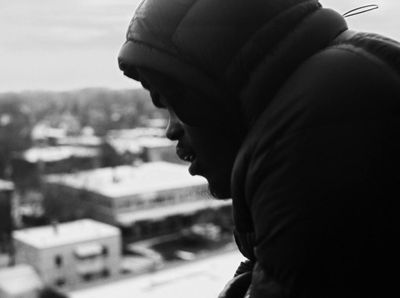 a black and white photo of a person looking out a window