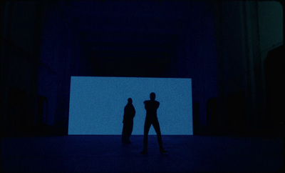 a couple of people standing in a dark room