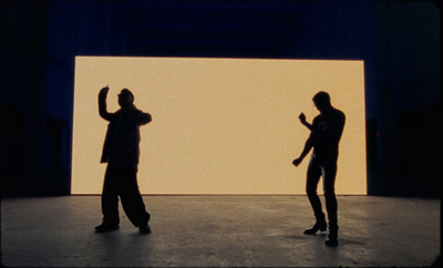 a couple of men standing in front of a white wall