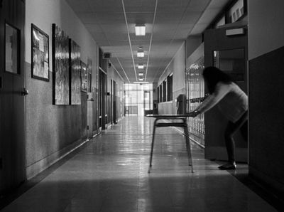 a woman walking down a hallway next to a table