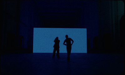 a couple of people standing in a dark room