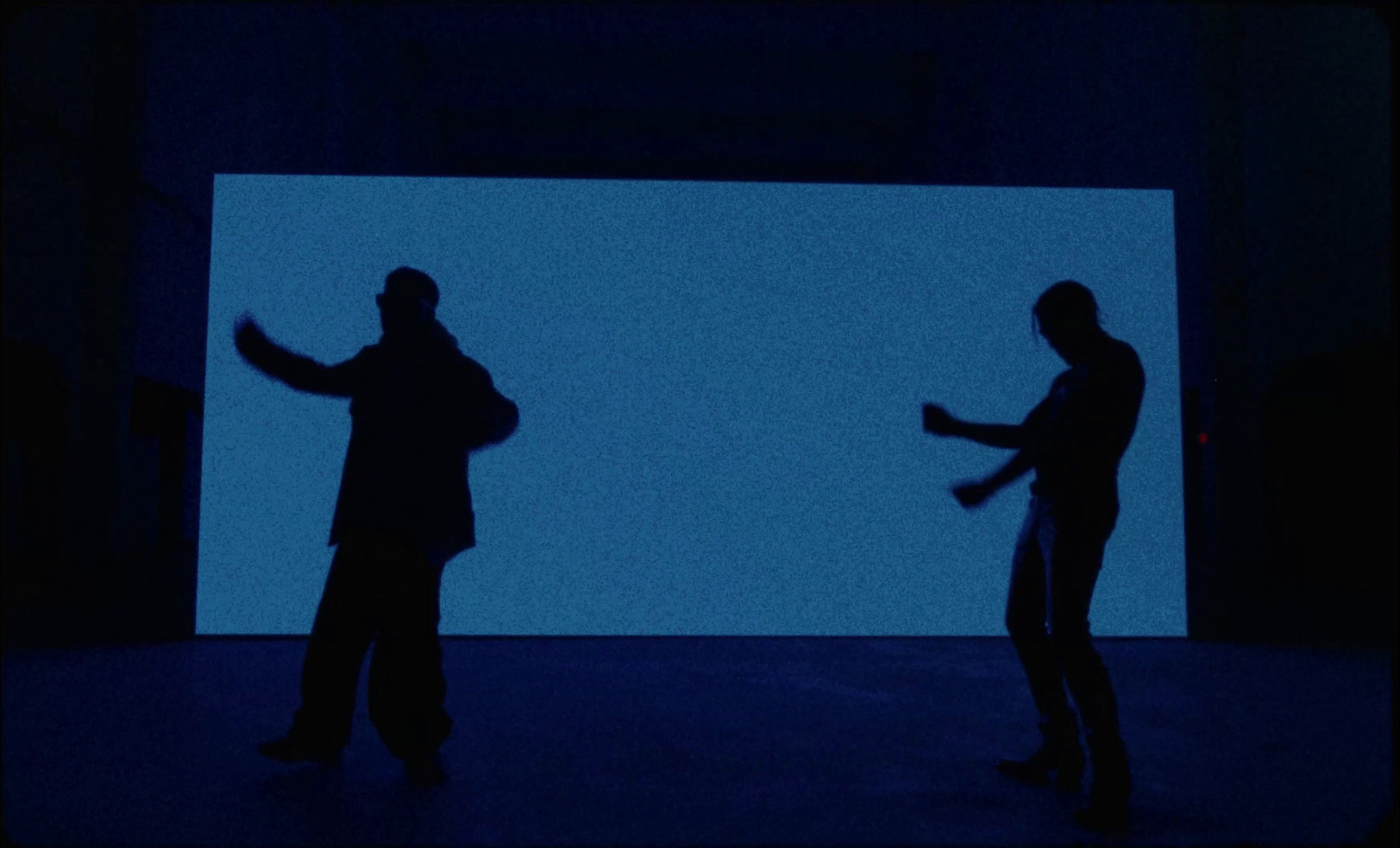 a couple of men standing in front of a blue screen