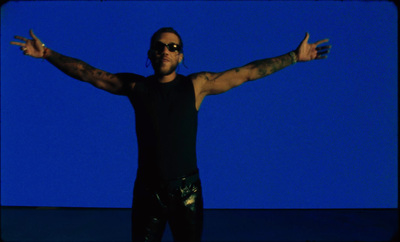 a man with his arms outstretched in front of a blue background