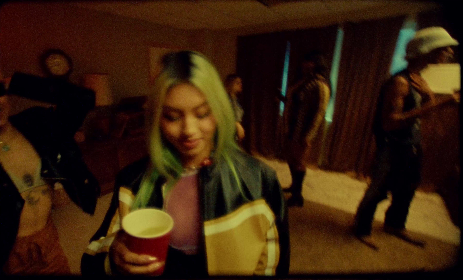 a woman with green hair is holding a cup