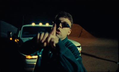 a man in sunglasses making a hand gesture