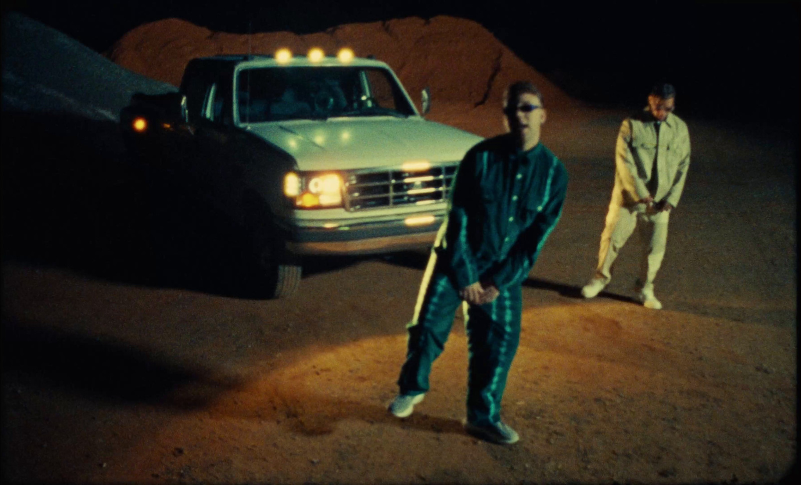 two men standing in front of a white truck