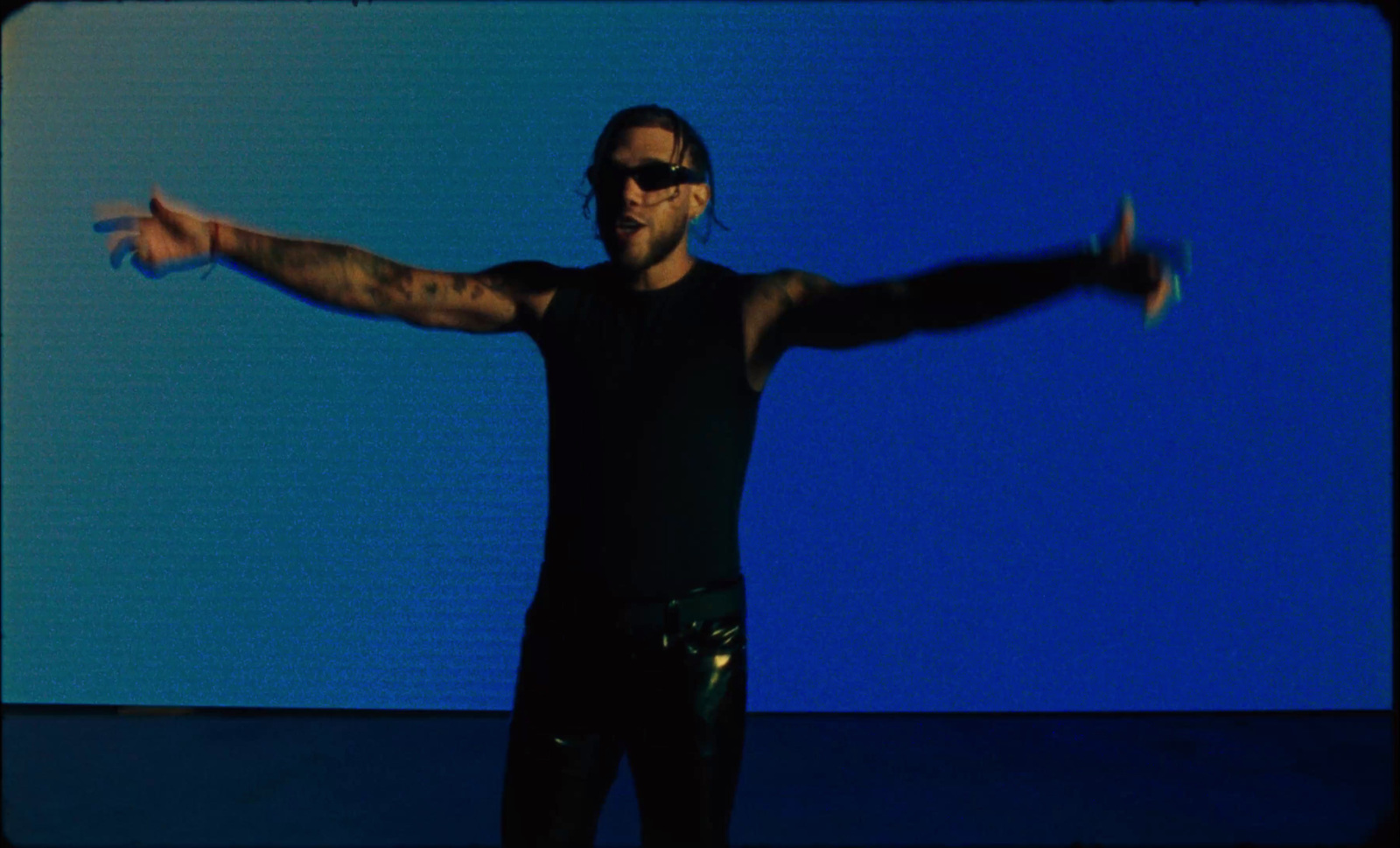 a man with his arms outstretched in front of a blue background