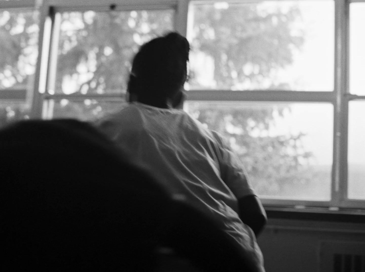 a man sitting in a chair looking out a window