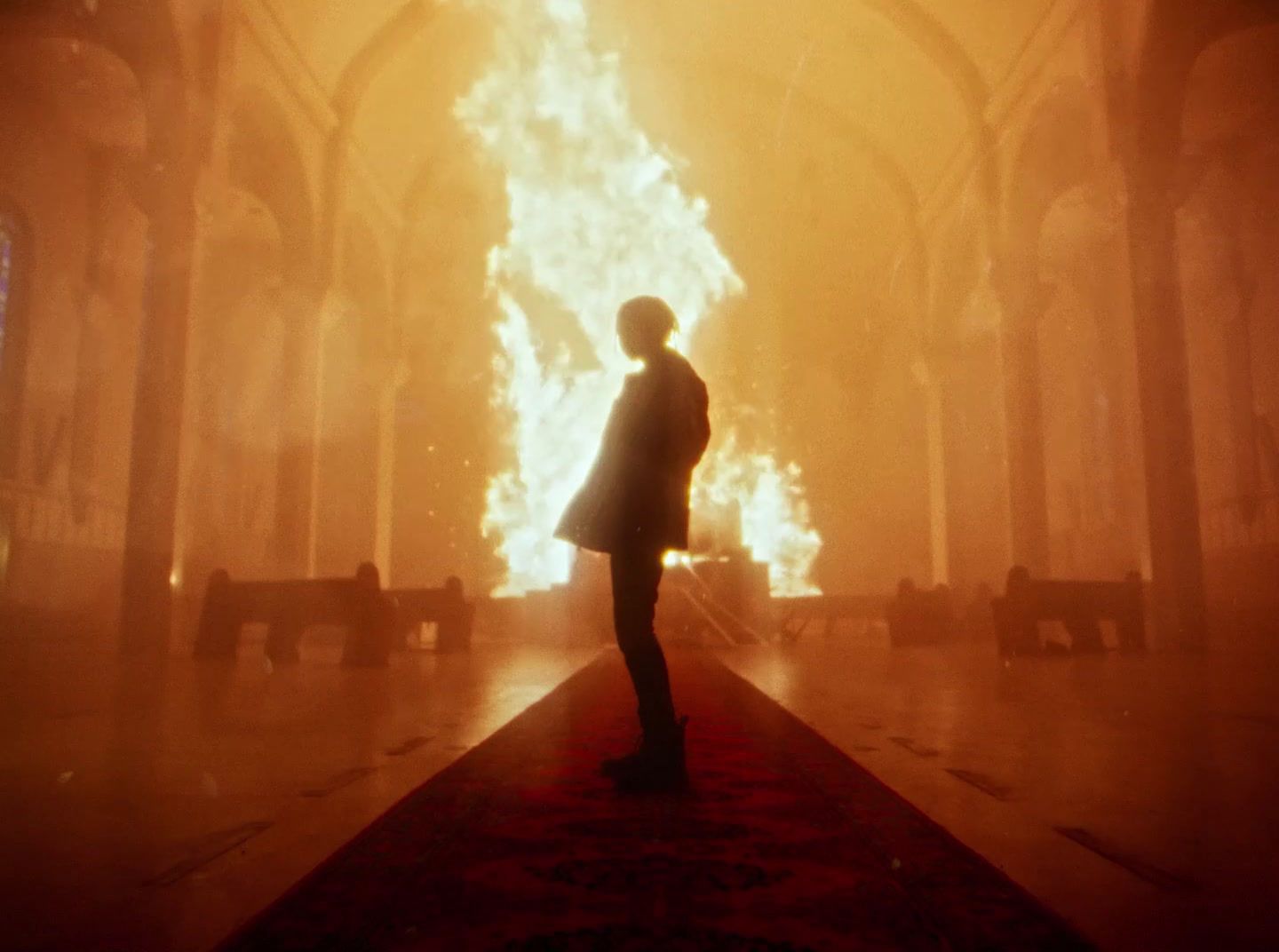 a man standing in front of a huge fire