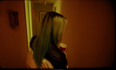 a woman with long green hair standing in front of a mirror