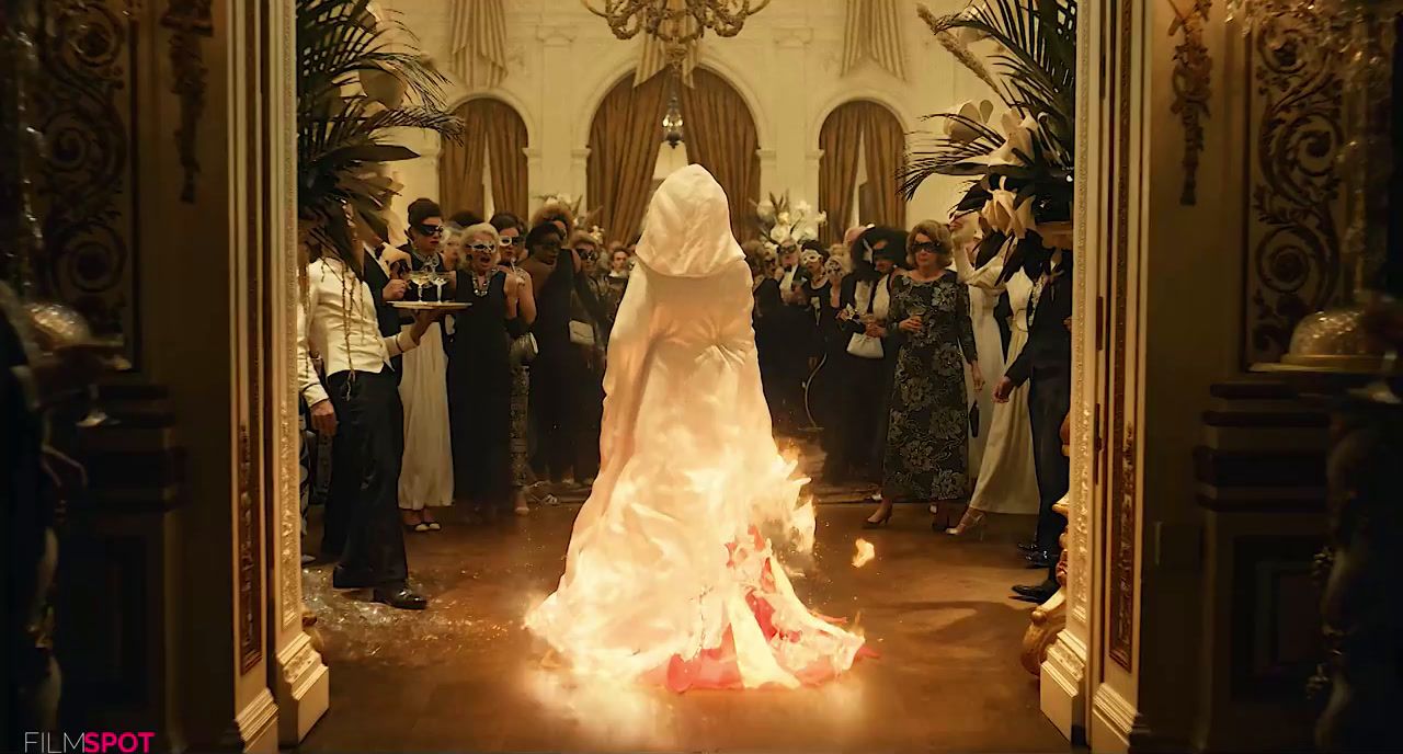 a woman in a white veil is standing in front of a group of people