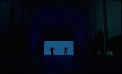 a couple of people standing in a dark room