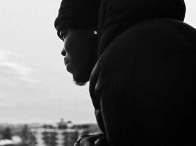 a black and white photo of a person looking out a window