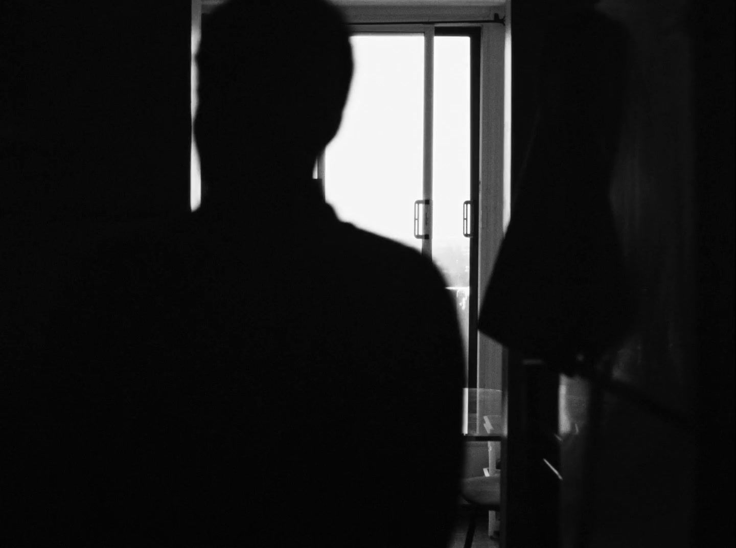 a black and white photo of a man in a dark room