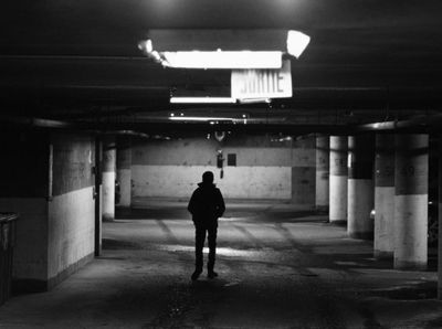 a person standing in an empty parking garage