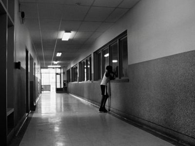 a woman is leaning against a wall in a hallway