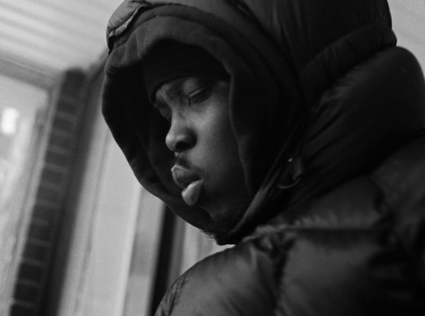 a black and white photo of a person wearing a hood