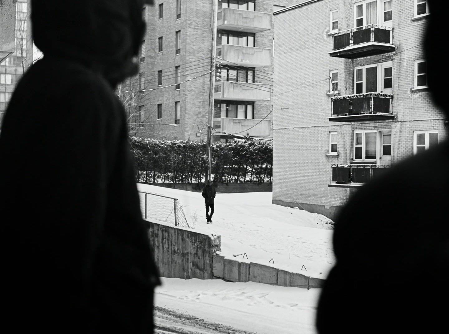 a black and white photo of a person walking in the snow