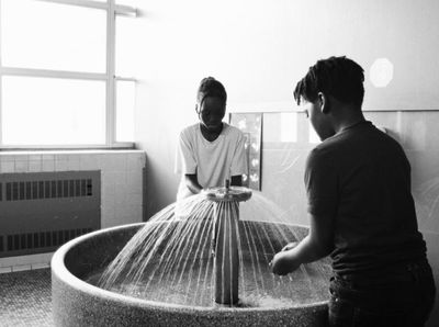 a couple of men standing in front of a water fountain