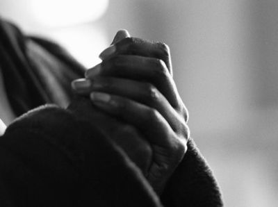 a black and white photo of a woman holding her hands together