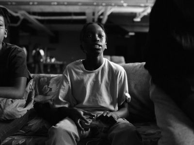 a black and white photo of two people sitting on a couch