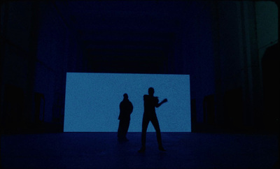 a couple of people standing in a dark room