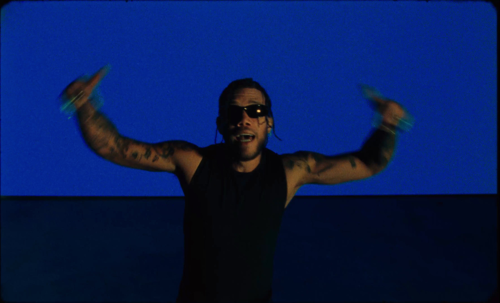 a man with his arms outstretched in front of a blue background