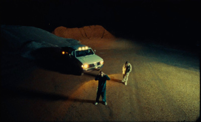 a man standing next to a police car in the dark