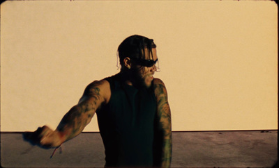 a man with tattoos on his arm holding a skateboard