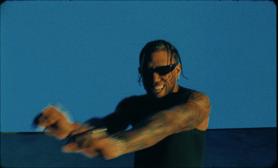 a man with long hair and sunglasses holding a white frisbee