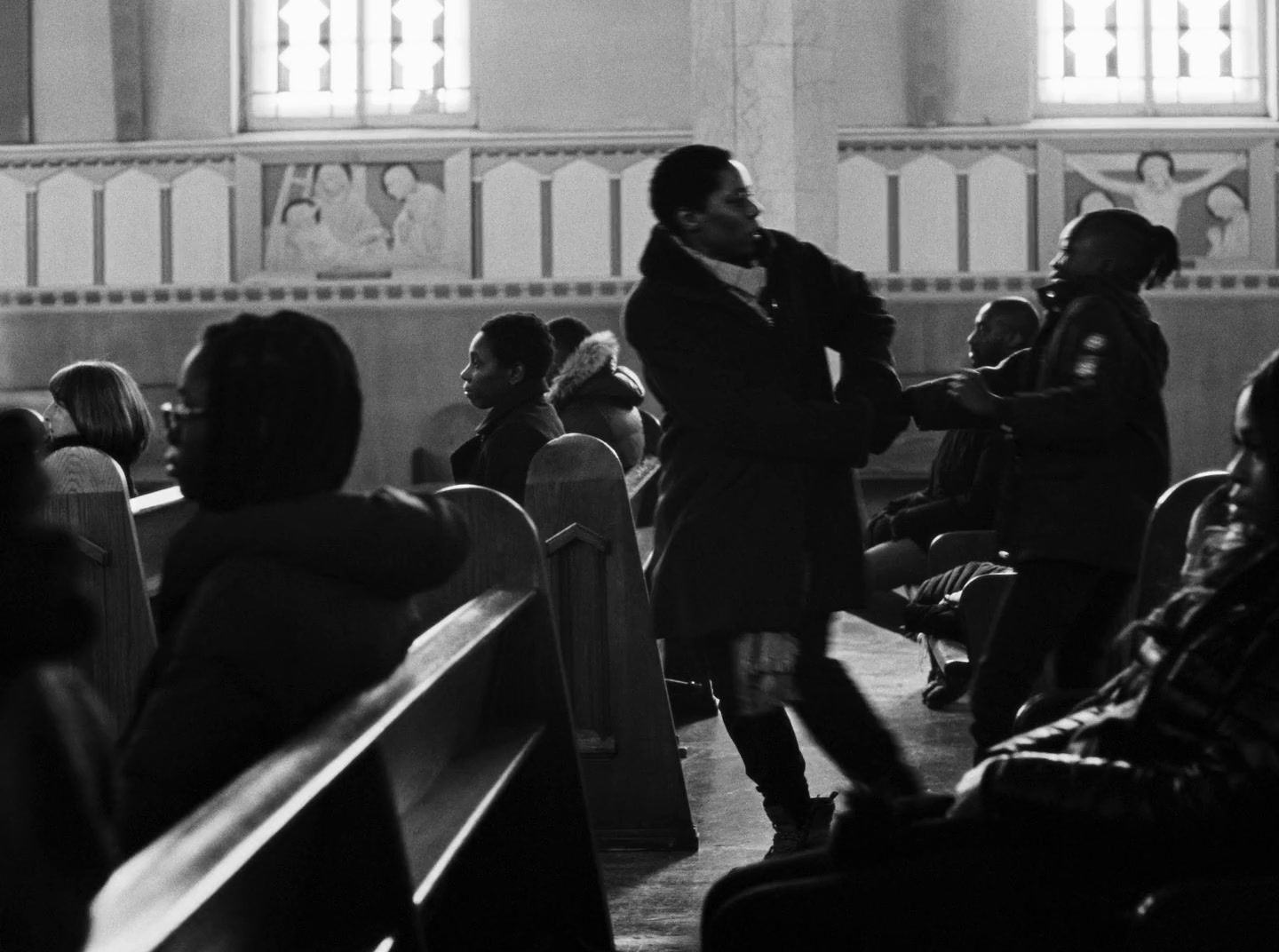 a black and white photo of people in a church