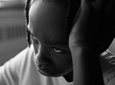 a young boy is holding his head in his hands