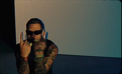 a man with tattoos on his arms making a peace sign