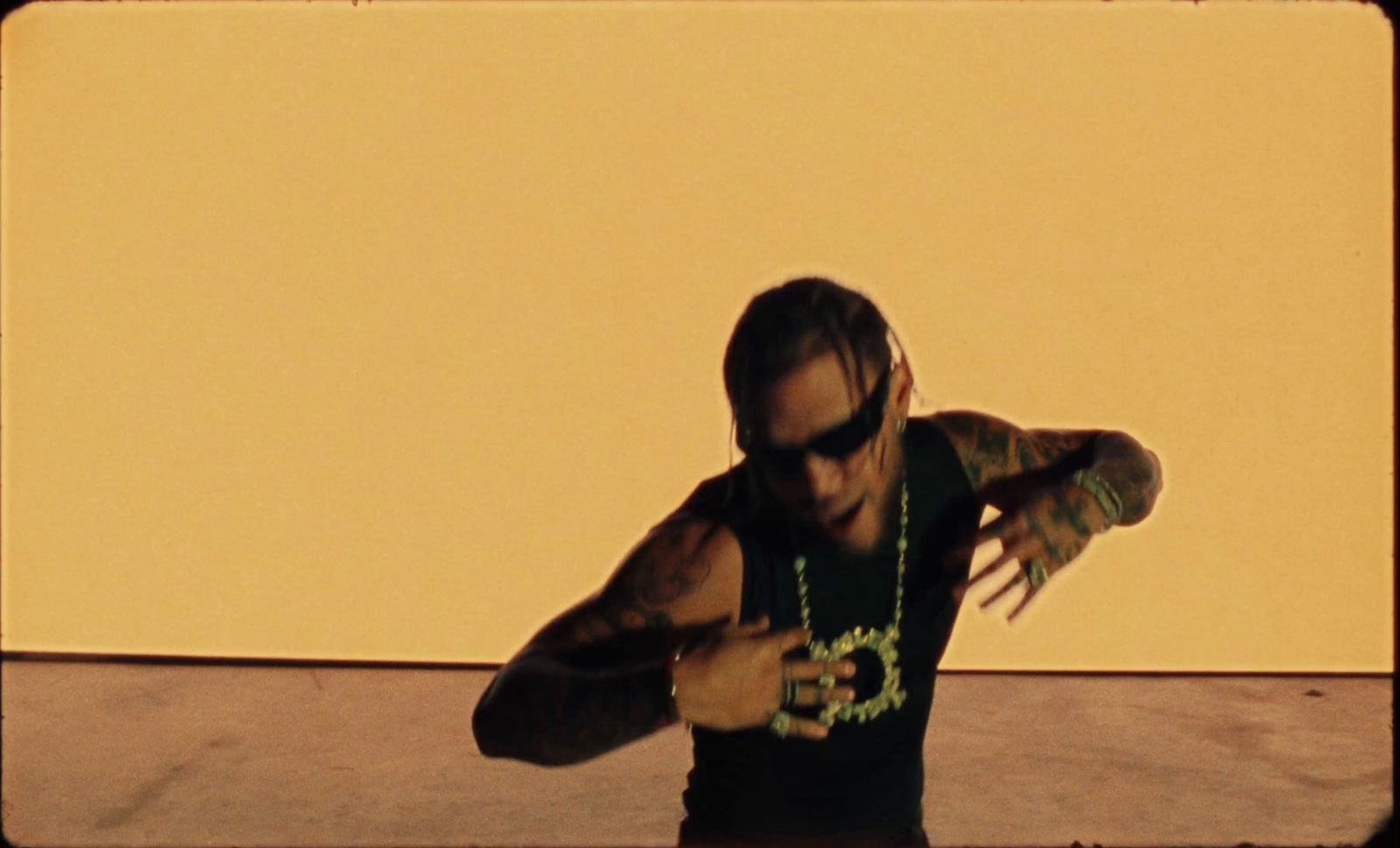 a man in a black shirt and some necklaces