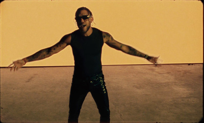 a man in a black shirt and green sequin pants