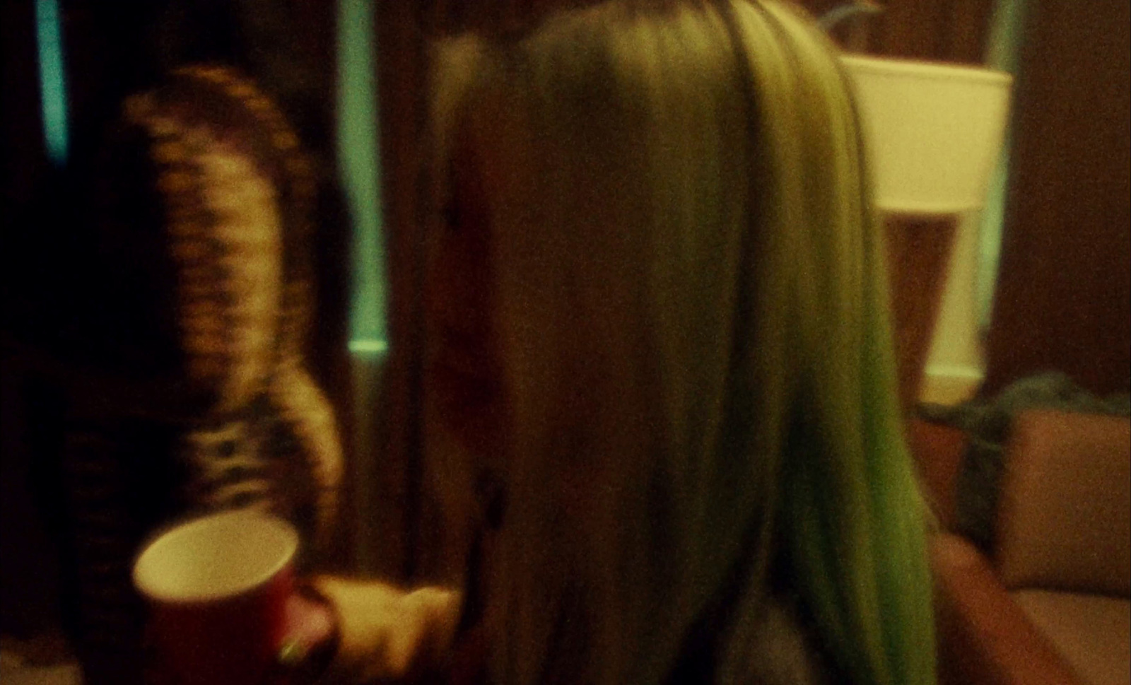 a woman with green hair holding a cup of coffee